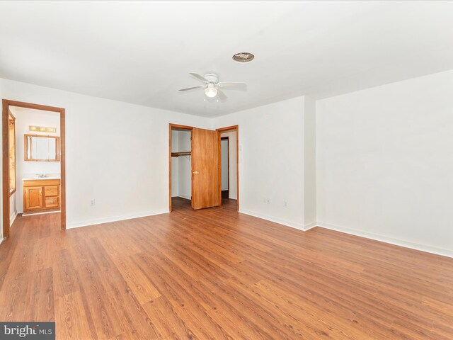 unfurnished bedroom with light hardwood / wood-style floors, ensuite bath, and ceiling fan