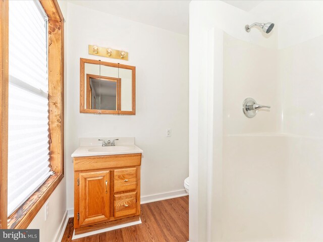 bathroom with vanity, toilet, walk in shower, and hardwood / wood-style floors