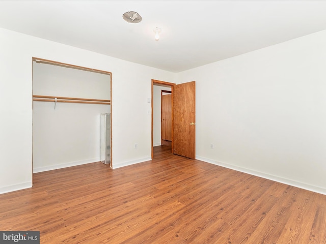 unfurnished bedroom with a closet and light wood-type flooring