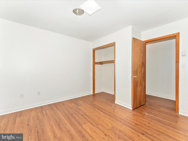 unfurnished bedroom with a closet and hardwood / wood-style flooring