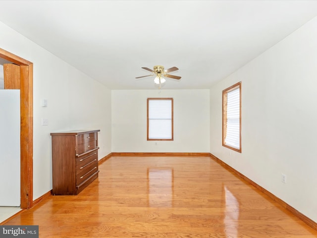 empty room with light hardwood / wood-style flooring and ceiling fan