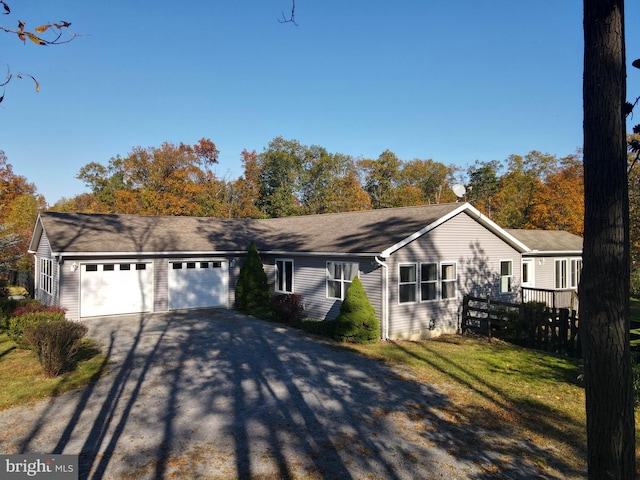 ranch-style house featuring a garage and a front yard