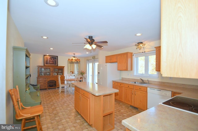 kitchen with a kitchen island, hanging light fixtures, sink, white appliances, and ceiling fan with notable chandelier