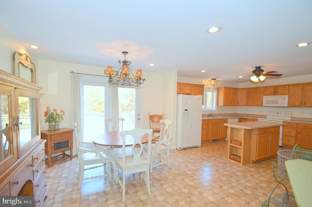 dining area with ceiling fan with notable chandelier, sink, and french doors