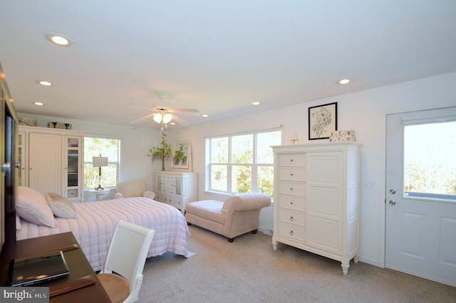 carpeted bedroom featuring multiple windows and ceiling fan