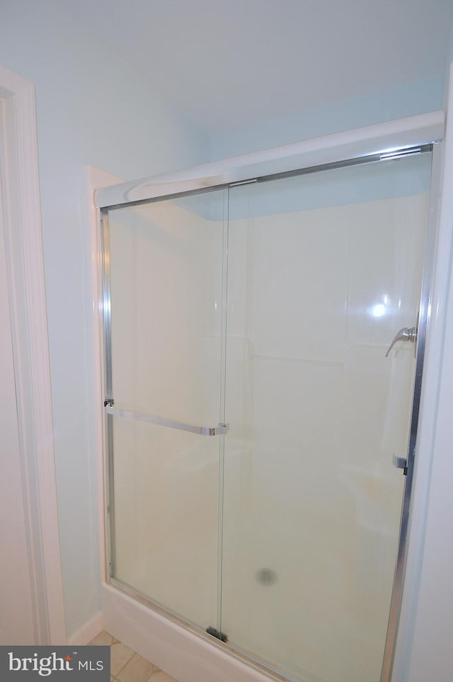 bathroom featuring a shower with door and tile patterned floors