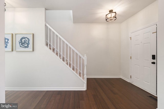 entrance foyer with dark hardwood / wood-style flooring and a chandelier