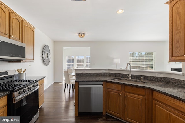 kitchen featuring a healthy amount of sunlight, appliances with stainless steel finishes, sink, and dark hardwood / wood-style flooring