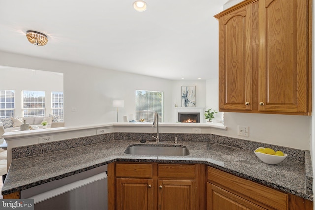 kitchen with a healthy amount of sunlight, kitchen peninsula, sink, and stainless steel dishwasher