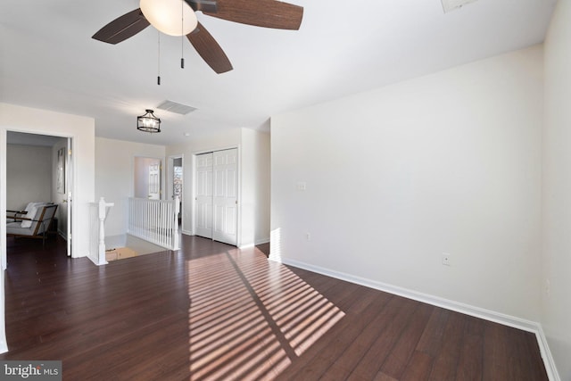 empty room featuring dark hardwood / wood-style flooring and ceiling fan