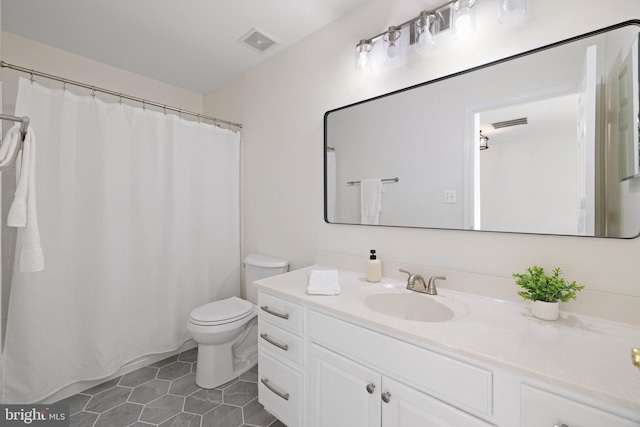 bathroom featuring tile patterned flooring, vanity, and toilet