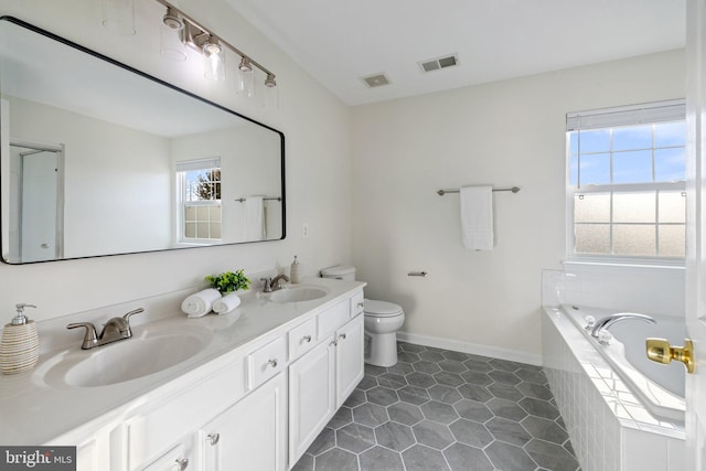 bathroom featuring vanity, tile patterned floors, toilet, and tiled tub