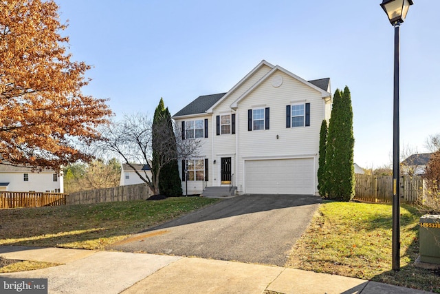 view of property featuring a garage and a front lawn