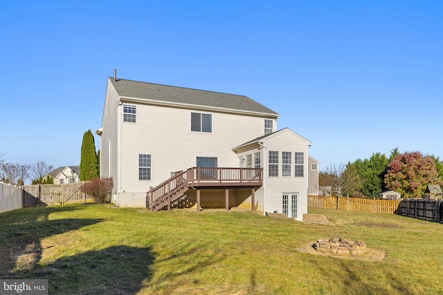 rear view of house with a deck and a yard