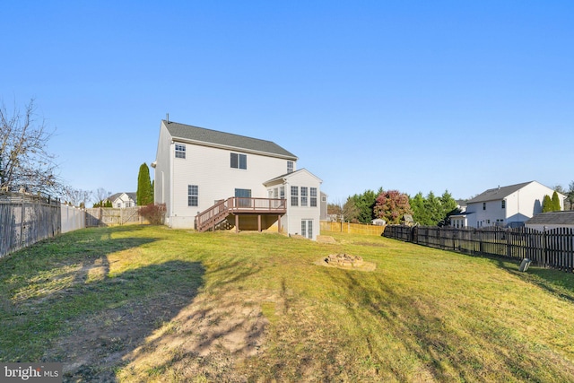 rear view of property with a yard and a deck