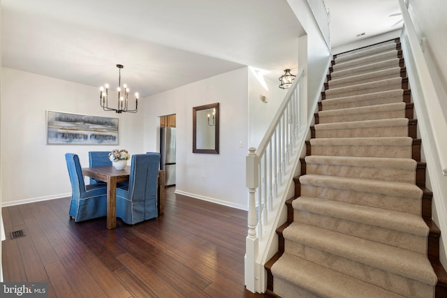 dining space featuring dark hardwood / wood-style floors and an inviting chandelier