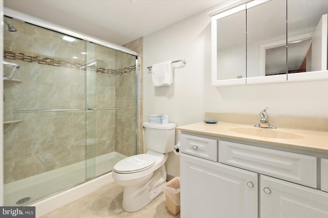 bathroom featuring toilet, a shower with shower door, and vanity