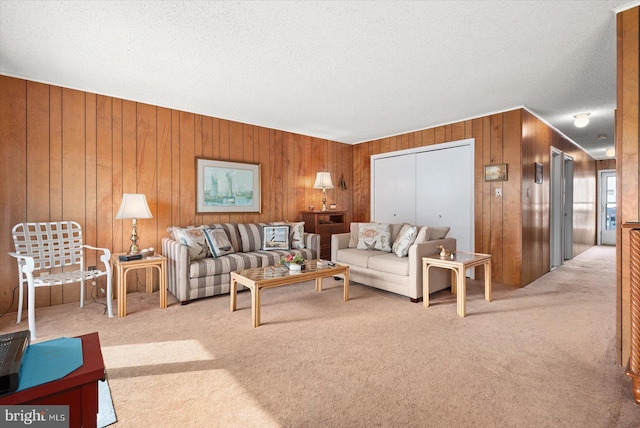 living room with light carpet, wood walls, and a textured ceiling