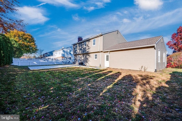 rear view of property featuring a lawn and a patio