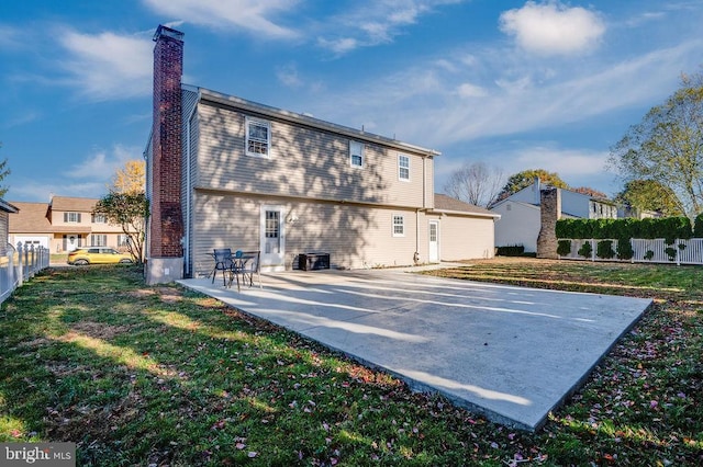 back of house with a patio area and a lawn