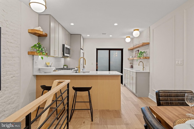 kitchen featuring a kitchen bar, kitchen peninsula, and backsplash