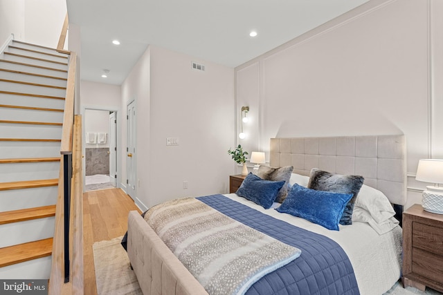 bedroom featuring light wood-type flooring and ensuite bath