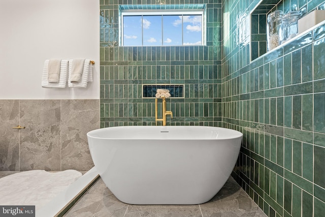 bathroom featuring a washtub and tile walls