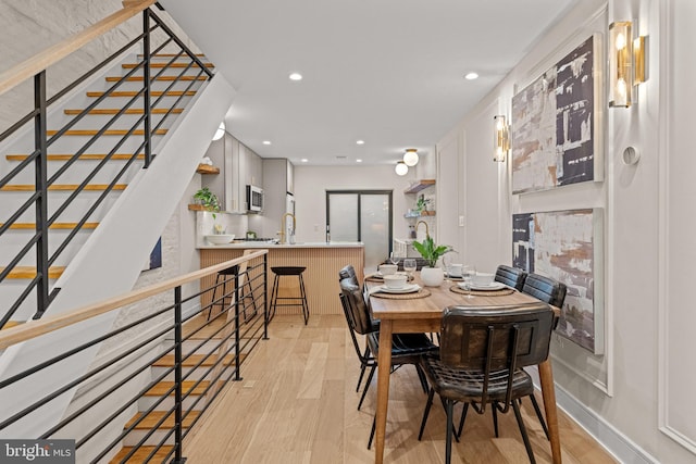 dining space with light hardwood / wood-style floors and sink