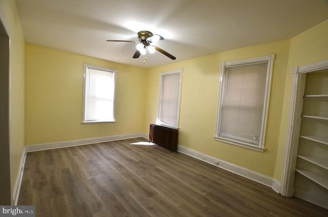 unfurnished room with radiator, ceiling fan, and dark hardwood / wood-style floors