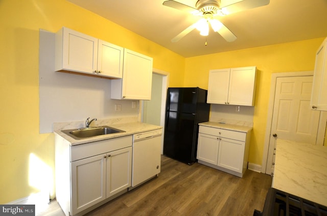 kitchen with white dishwasher, sink, black refrigerator, and white cabinets