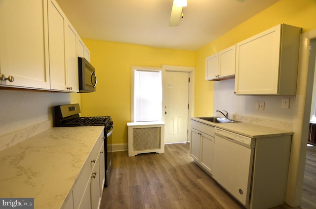 kitchen with white dishwasher, sink, stainless steel range with gas stovetop, white cabinets, and dark hardwood / wood-style flooring