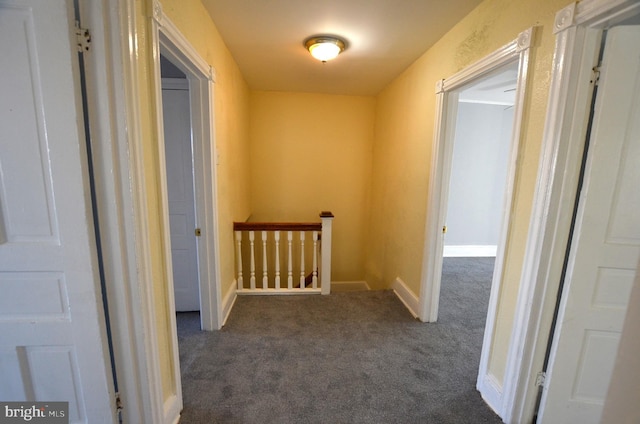 hallway featuring dark colored carpet