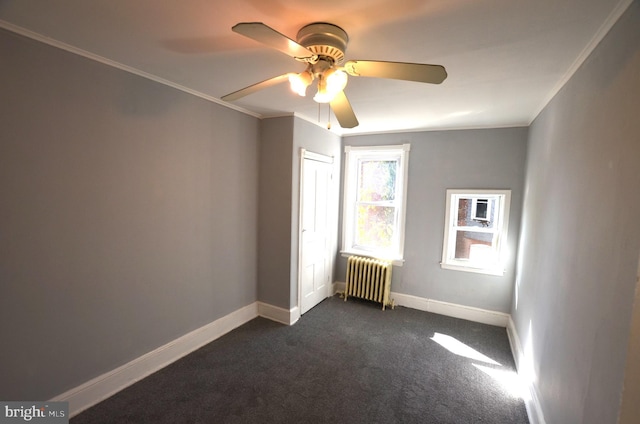 carpeted empty room featuring radiator, ceiling fan, and crown molding