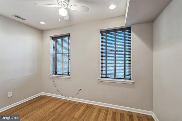 unfurnished room featuring wood-type flooring, plenty of natural light, and ceiling fan