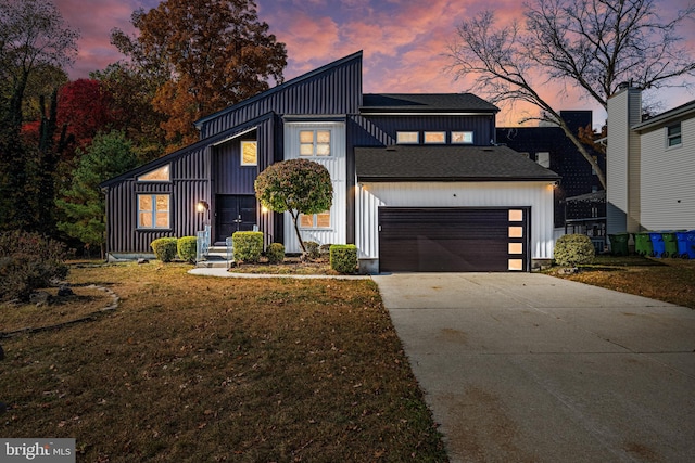 view of front of property with a garage and a lawn