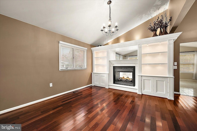 unfurnished living room with dark hardwood / wood-style floors, a multi sided fireplace, a chandelier, and vaulted ceiling