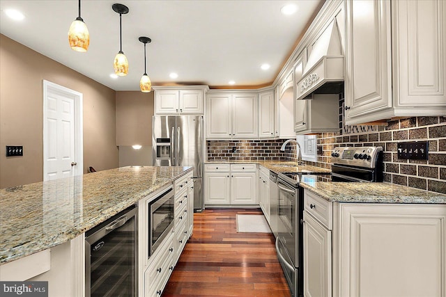 kitchen featuring hanging light fixtures, light stone countertops, white cabinetry, stainless steel appliances, and beverage cooler