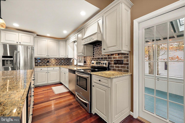 kitchen with white cabinetry, hanging light fixtures, dark hardwood / wood-style flooring, premium range hood, and appliances with stainless steel finishes