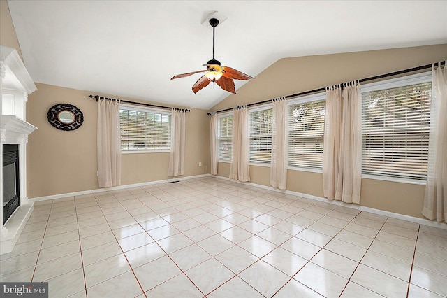 39 Admiral Ave, Ocean Pines, MD 21811 - unfurnished living room with ceiling fan, vaulted ceiling, a glass covered fireplace, light tile patterned floors, and baseboards
