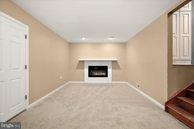 39 Admiral Ave, Ocean Pines, MD 21811 - unfurnished living room with light colored carpet, baseboards, a glass covered fireplace, and stairs
