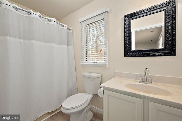 bathroom with toilet, vanity, and hardwood / wood-style flooring