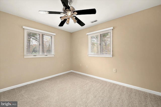 unfurnished room featuring ceiling fan, carpet floors, and a wealth of natural light