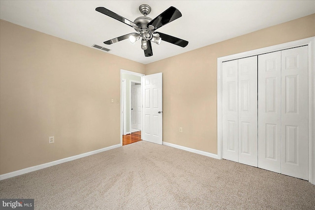 unfurnished bedroom with ceiling fan, a closet, and carpet