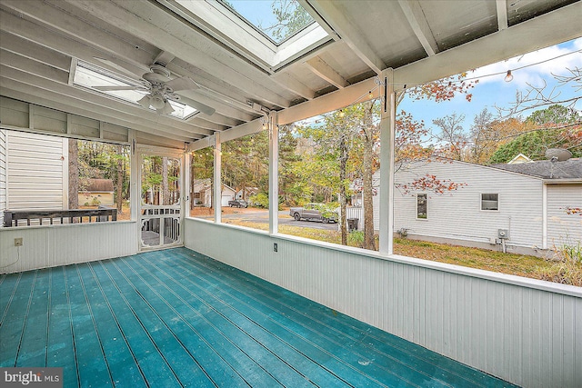 unfurnished sunroom featuring ceiling fan and vaulted ceiling with skylight