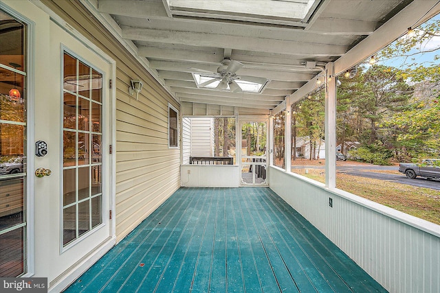 unfurnished sunroom featuring ceiling fan and vaulted ceiling with skylight