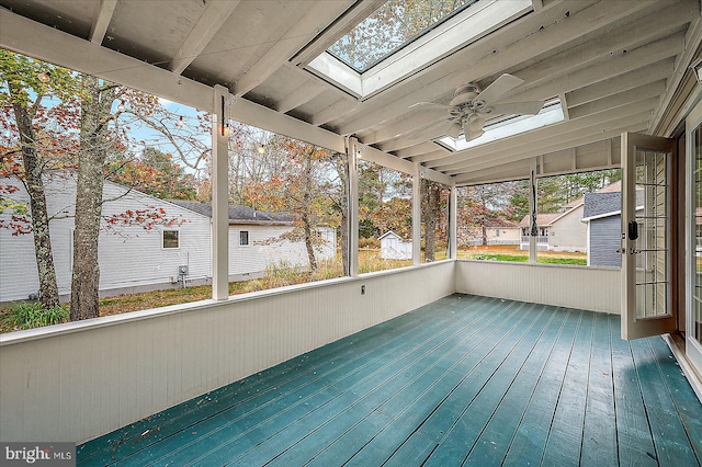 unfurnished sunroom featuring ceiling fan and vaulted ceiling with skylight