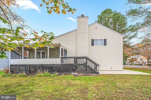 view of side of home featuring a lawn and a sunroom