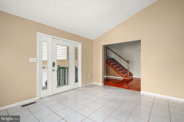 foyer entrance featuring light tile patterned flooring and vaulted ceiling