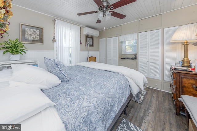 bedroom with dark hardwood / wood-style flooring, multiple windows, a wall mounted AC, and ceiling fan