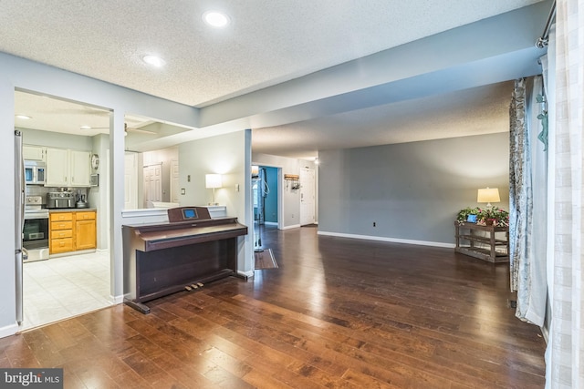 interior space featuring light hardwood / wood-style flooring, white cabinetry, a textured ceiling, and stainless steel appliances